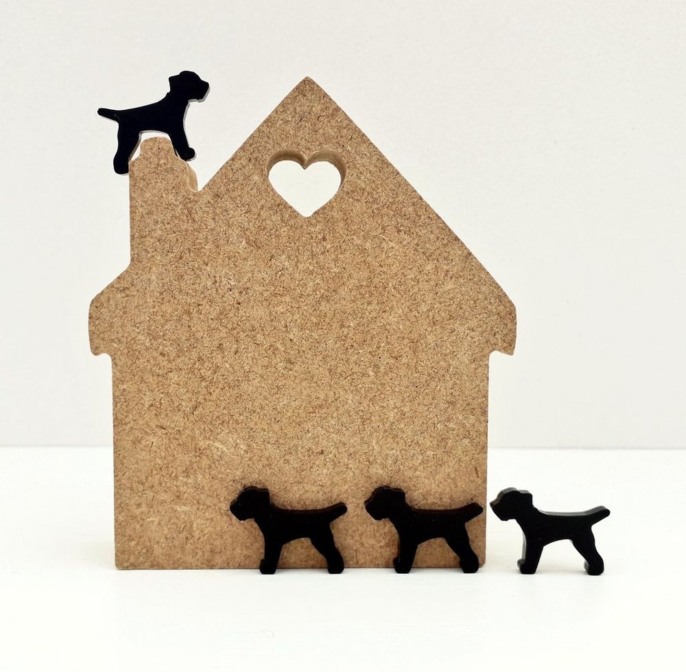 A small house shaped wooden block with black acrylic border terrier shapes in the misheleneous logo design