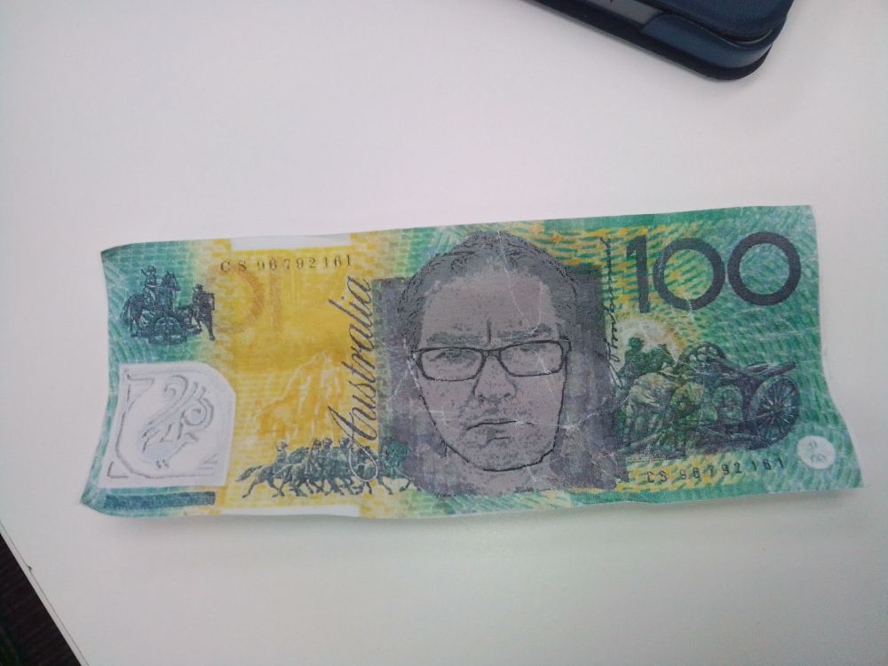 A reproduction of an Australian $100 bill with the posters' face on it.