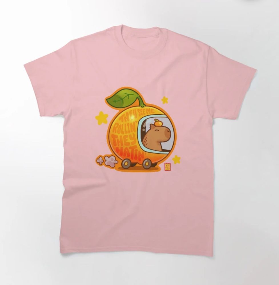 Shirt sample: illustration on a light pink shirt in the style of Richard Scarry’s Lowly Worm apple car except it’s a capybara driving a yuzu shaped car. Lettering on the side of the car reads “they see me rollin’. They hatin’. ”