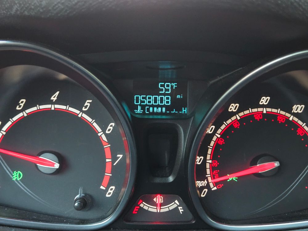 Dashboard instrument cluster of a car. The odometer reads "058008 mi" which references an old joke from viewing calculators' displays upside down