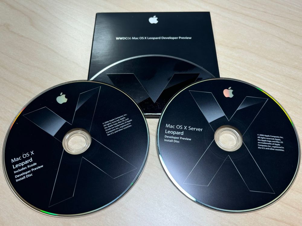A picture of 2 Mac OS X Leopard DVD Installer disks. Above is the WWDC 2006 protective sleeve.