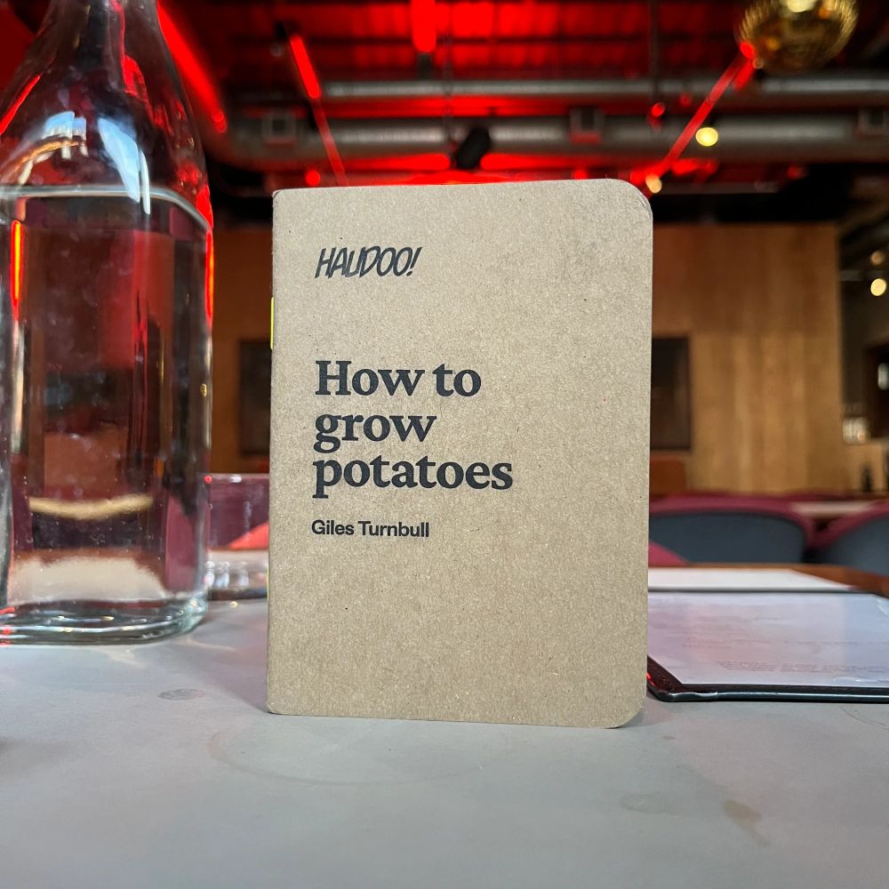 A small brown book called How to grow potatoes by Giles Turnbull