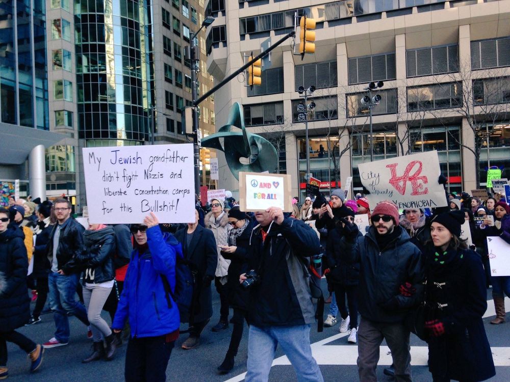 A picture of a march from 2017. I am wearing a blue coat and holding a sign that says "My Jewish grandfather didn't fight Nazis and liberate concentration camps for this Bullshit!"
