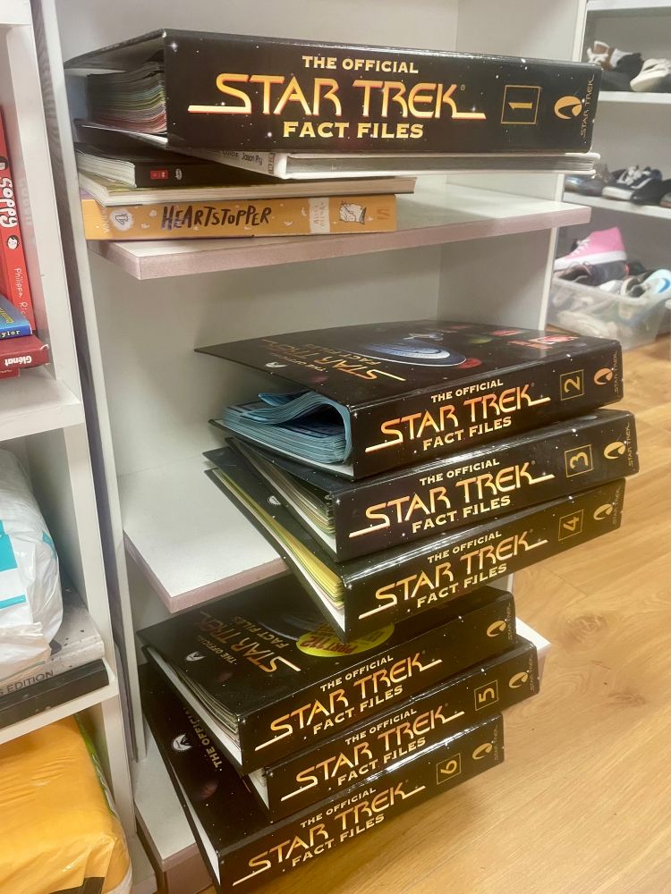 Photo of charity shop shelves with 7 binders of the Star Trek fact files magazine 