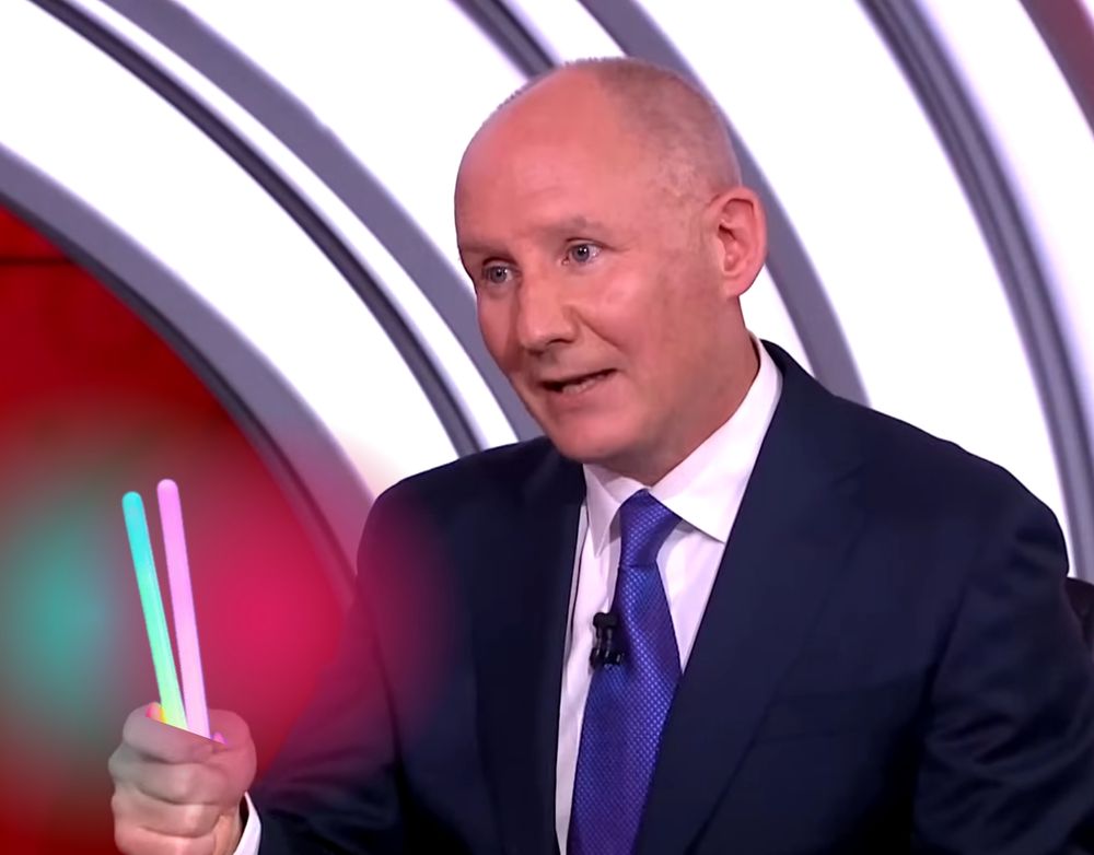 photoshopped picture of jim gavin in the presidential debate, holding two glowsticks