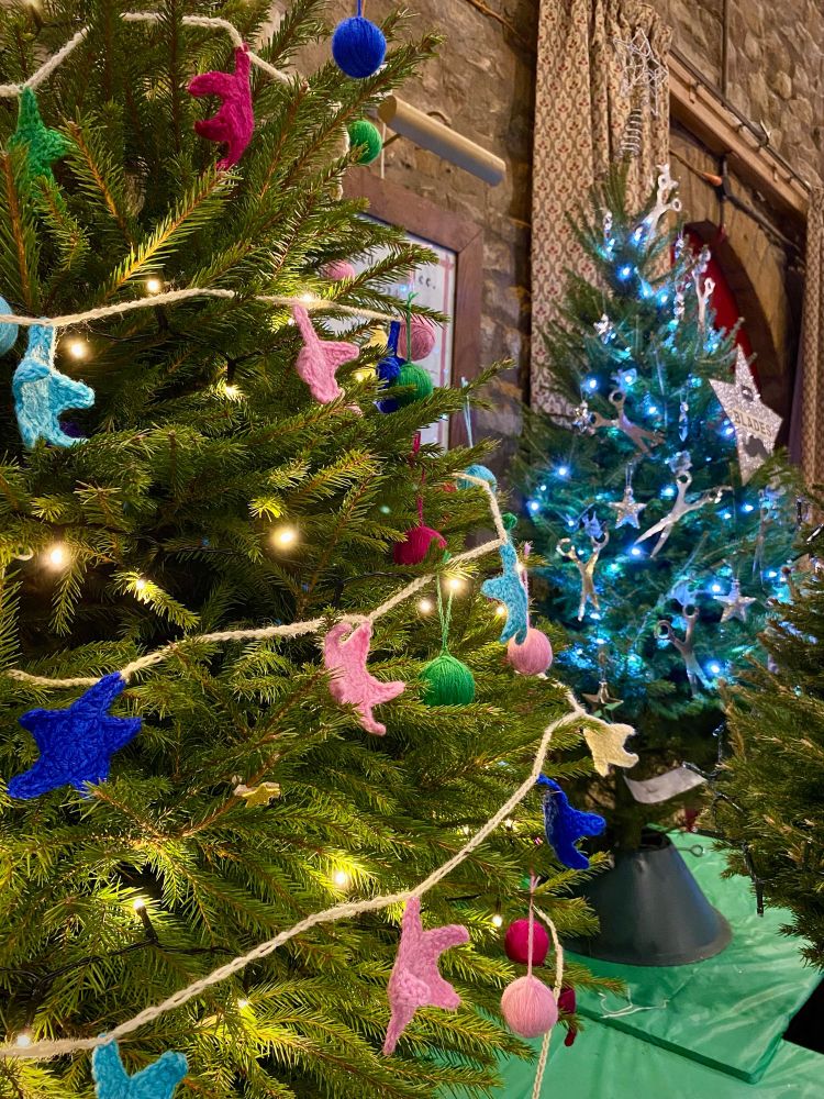 A tree with crocheted stars and yarn balls on