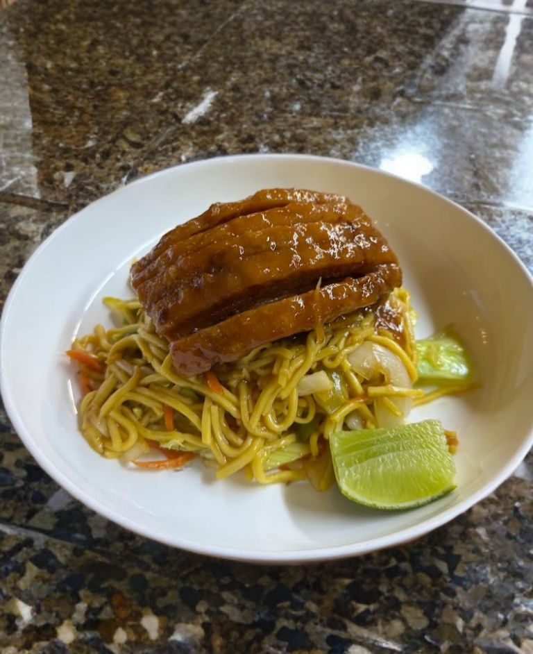Dish named 'Short Rib Adobo' served on a plate, kept on the serving counter