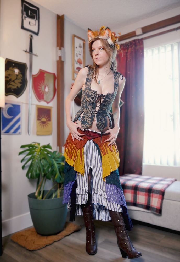 Wowzerz dressed as an original fox character. She is standing with her left leg kicked out in the heel with her hand on her waistband of her skirt.
