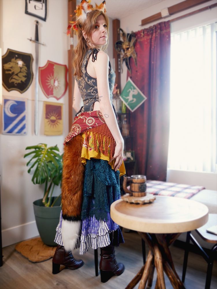 Wowzerz dressed as an original fox character. She is standing with her back to the camera to show off her tail.
