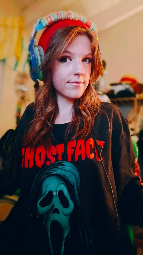 Wowzerz in a Ghost Face sweatshirt and a computer headset