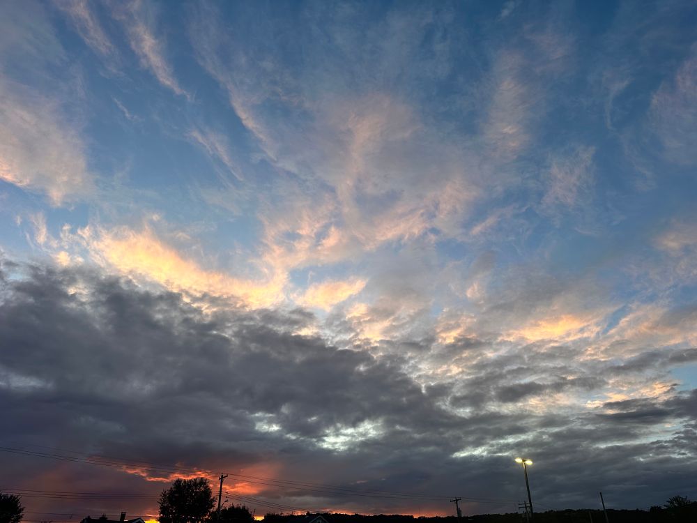 Sunset-tinged horizon, with partly mood clouds, and bright wispy ones, on a gorgeous evening, late August. 