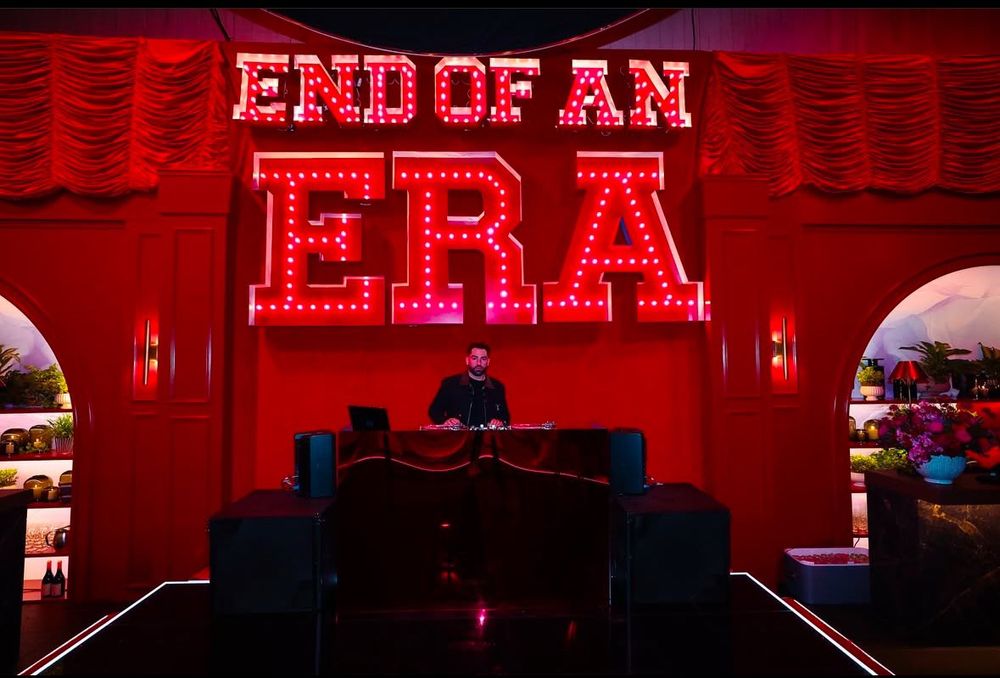 Light up sign saying ‘end of an era’ behind a DJ’s booth