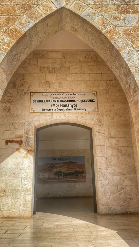 Manastırın girişindeki bilgilendirme tabelası ve taş kapı, bin yıllık bir geçmişin sessiz bekçiliğini yapıyor.

The entrance plaque and stone gate silently guard a history spanning a thousand years.

# #HistoricalPlaces #MardinHeritage #SacredGate #Deyrulzafaran #CulturalCompass