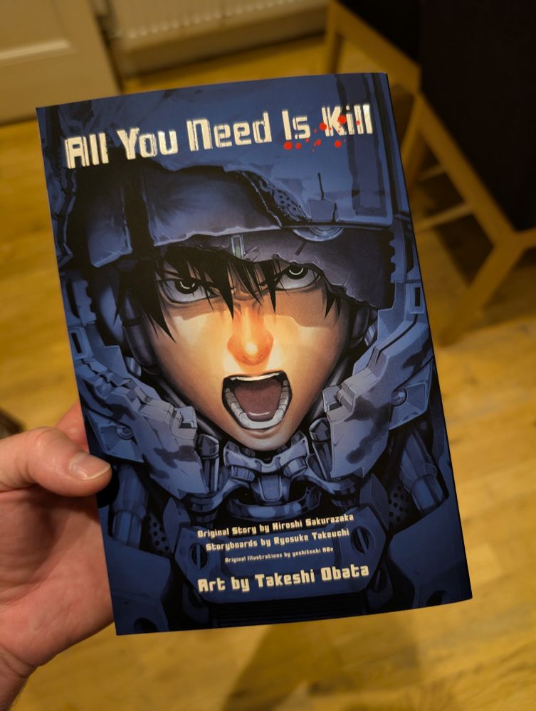A copy of the manga adaptation of All You Need Is Kill, illustrated by Takeshi Obata, storyboarded by Ryosuke Takeuchi, and based on the original light novel from Hiroshi Sakurazaka, which was turned into the movie Edge of Tomorrow starring Tom Cruise and Emily Blunt
