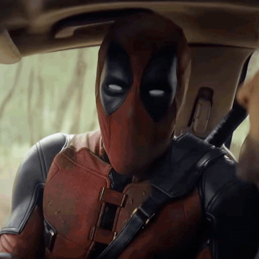 a man in a deadpool suit is sitting in a car