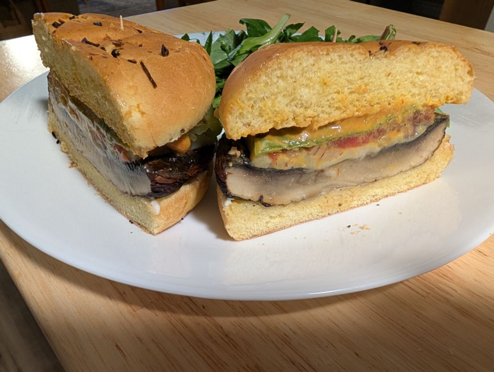 portabella burgers with grilled hatch chiles on front of a salad
