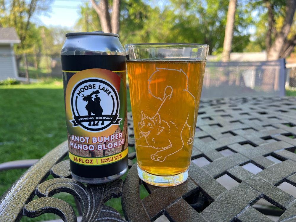 Moose Lake Brewing Co’s Knot Bumper Mango Blonde and a pint glass with an etching of a dog on it with its rump in the air. Hey, don’t look at me! I’m just describing the thing!!
