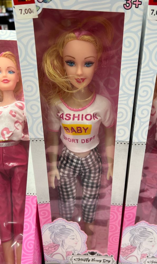 A knock off Barbie who’s shirt says “Fashion Baby Sport Dept”