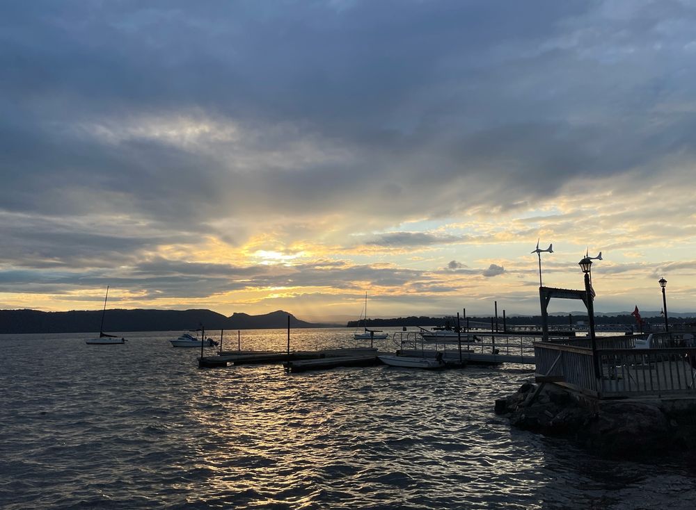 Sunset peeking through clouds over the Hudson River.