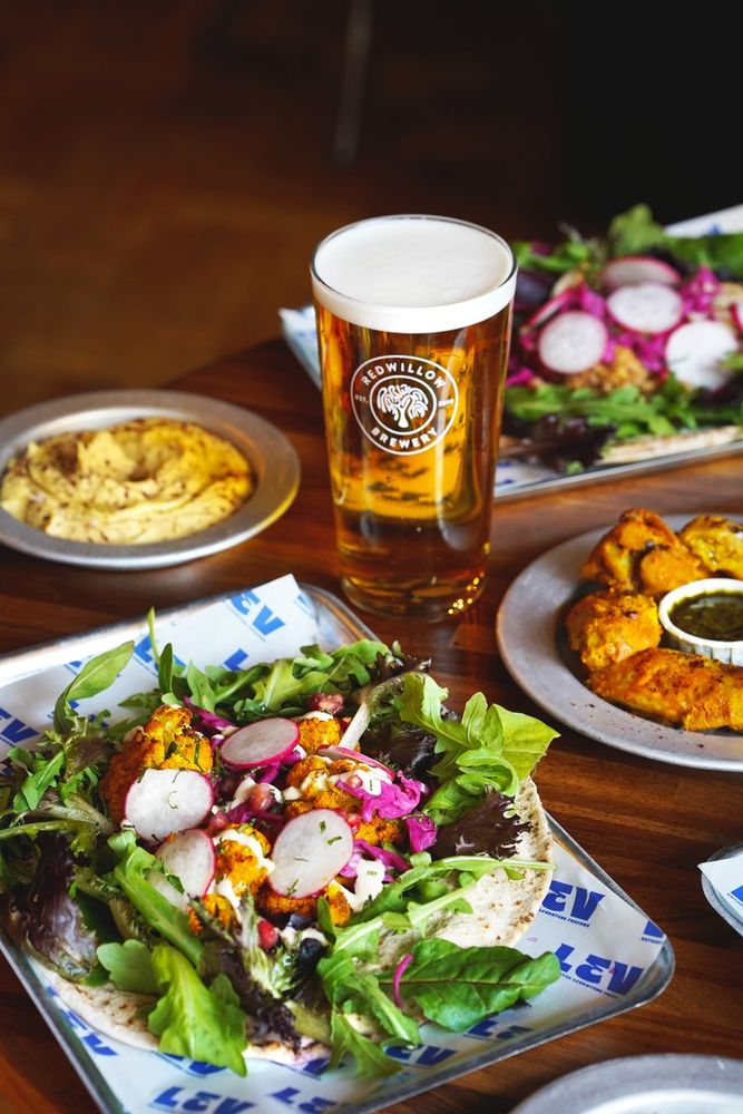 Plates of Lebanese style food with a pint of Redwillow beer at their macclesfield bar