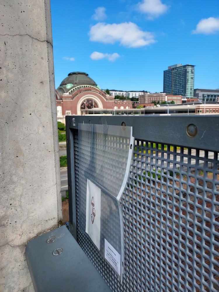 mushroom art print on an overpass bridge with a historical building in the background