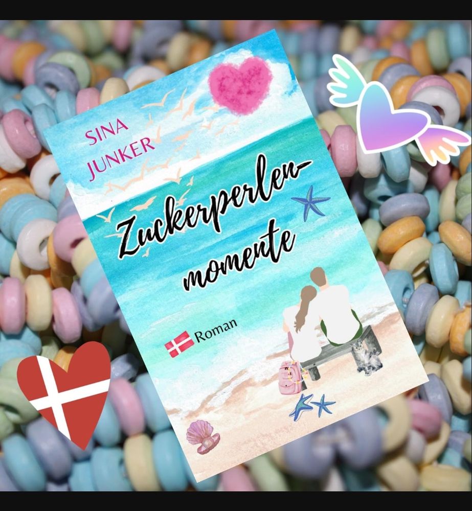 Screenshot:

Das Cover des Buchs Zuckerperlenmomente. Auf dem Cover sieht man gezeichnet von hinten ein Paar das auf einer Bank sitzt und auf's Meer schaut.

Oben links ist der Name der Autorin abgedruckt (Sina Junker)

Im Hintergrund des Screenshots sieht man Zuckerperlenketten und Herzen