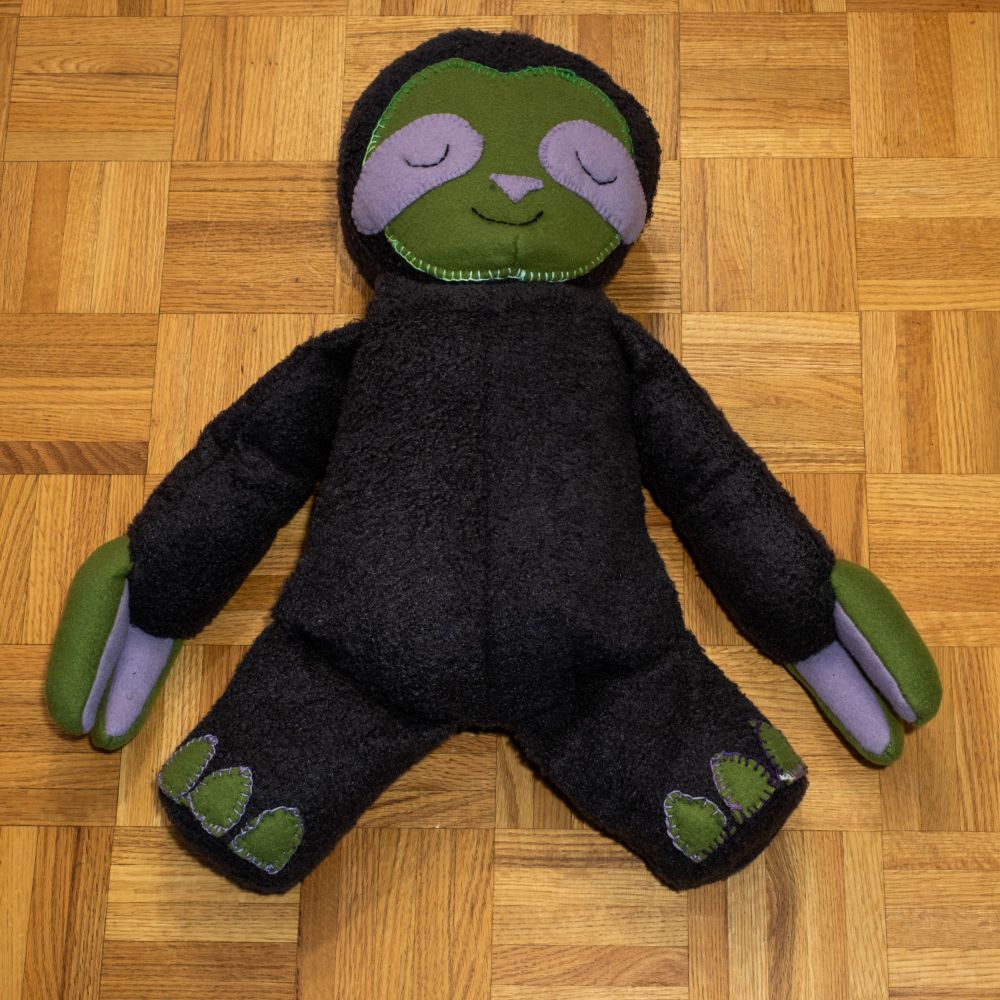 A sloth plushie. It has a sleepy face and is very soft and cuddly.