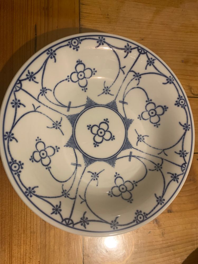 Tiefer Teller des Designs Tallin Indisch Blau. Er steht auf einem Holztisch.