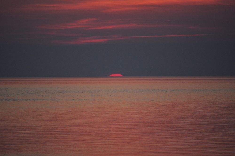 Last sliver of sun before it disappears below the horizon.