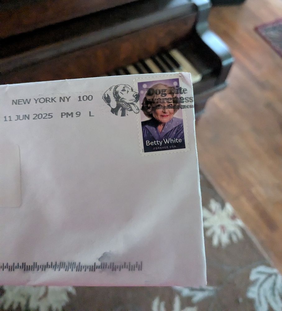 Betty White stamp on an envelope. There is a cool piano in the background.