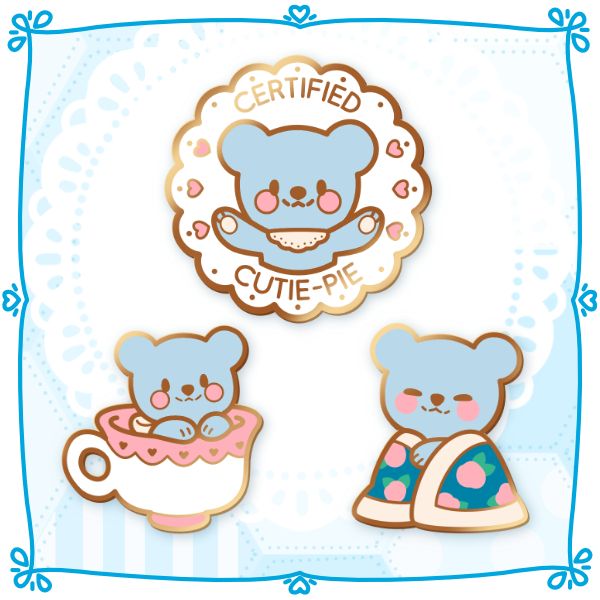 Three pin designs. One is a round pin with scalloped edges. It says "Certified Cutie Pie" and has Doily in the middle with their arms out in a hugging motion. There are hearts on either side of them.
Second pin is Doily sitting inside a tea cup. The teacup has a pink border with hearts at the top.
The third pin has doily cuddled up in a floral print blanket, smiling contently.