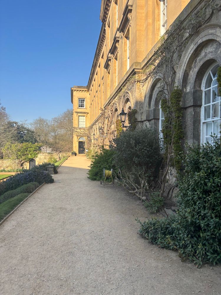 A pretty path next to a stone college building which is soaked in beautiful yet transient British sunshine. 