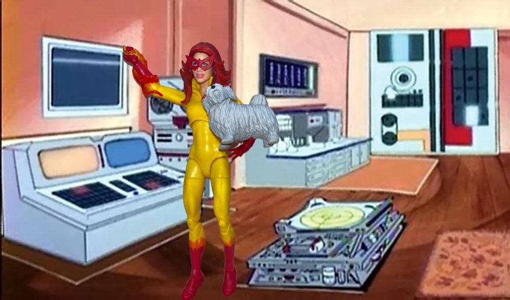 Firestar, with Ms. Lion in the crook of her left arm, stands “in” the apartment lair from Spider-Man and his Amazing Friends.