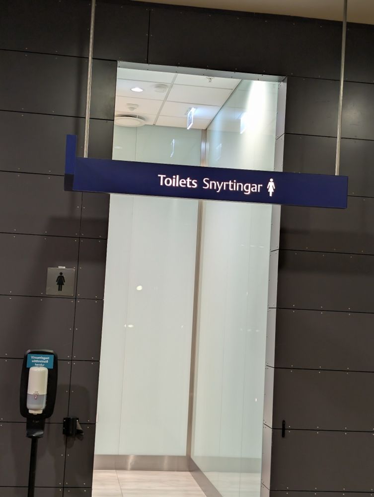 The toilet entrance at Reykjavik airport shows English and Icelandic words. 