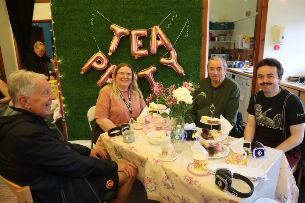 4 people sitting at table with tea within the NRFG community centre