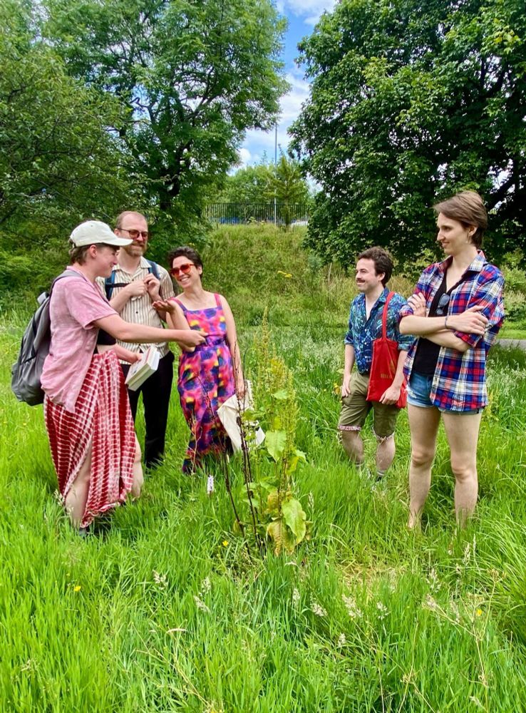 Greens smiling together gathered round an orchid