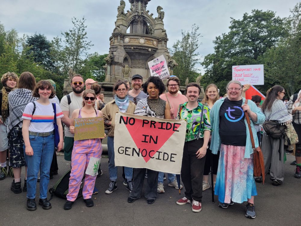 Collection of Green members smiling to camera - main sign in centre reads no Pride in Genocide 
