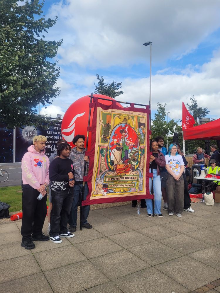 Workers from the Village Hotel standing beside the Unite Hospitality banner 