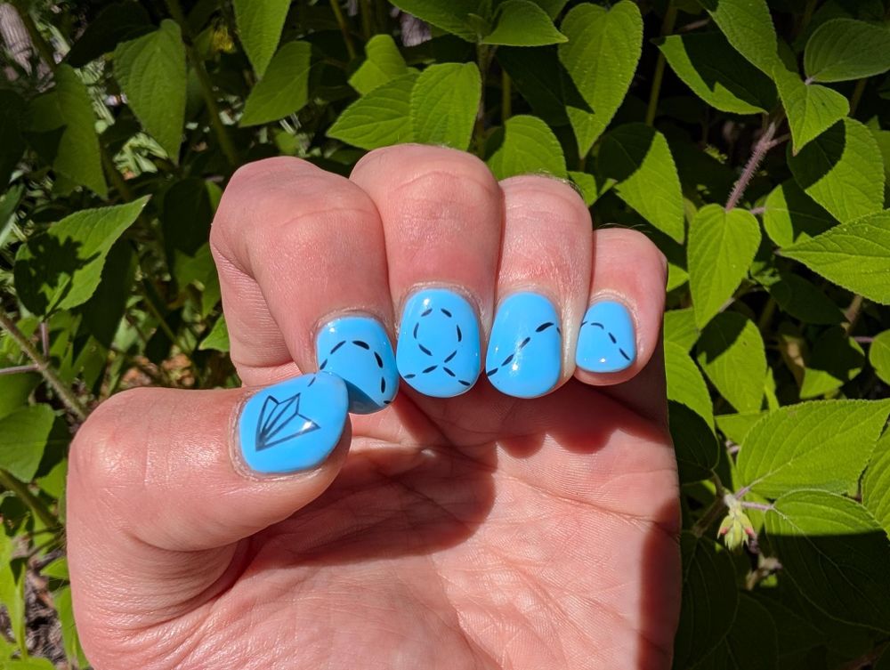A photo of Robin's nails against a backdrop of a healthy pineapple sage plant. Her nails are painted Robin's egg blue and feature a paper airplane on the thumbnail, with a swirly dashed line behind it that goes from thumb to pinky suggestive of it flying across the finger nails.