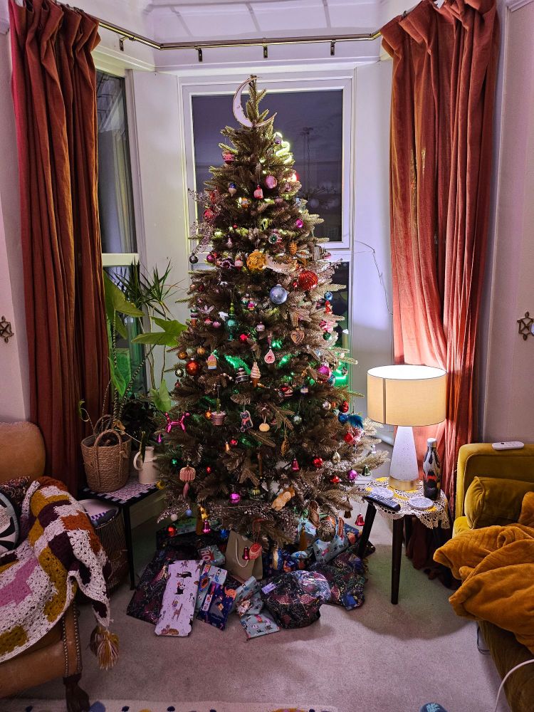 Gold fake Christmas tree with colourful baubles 