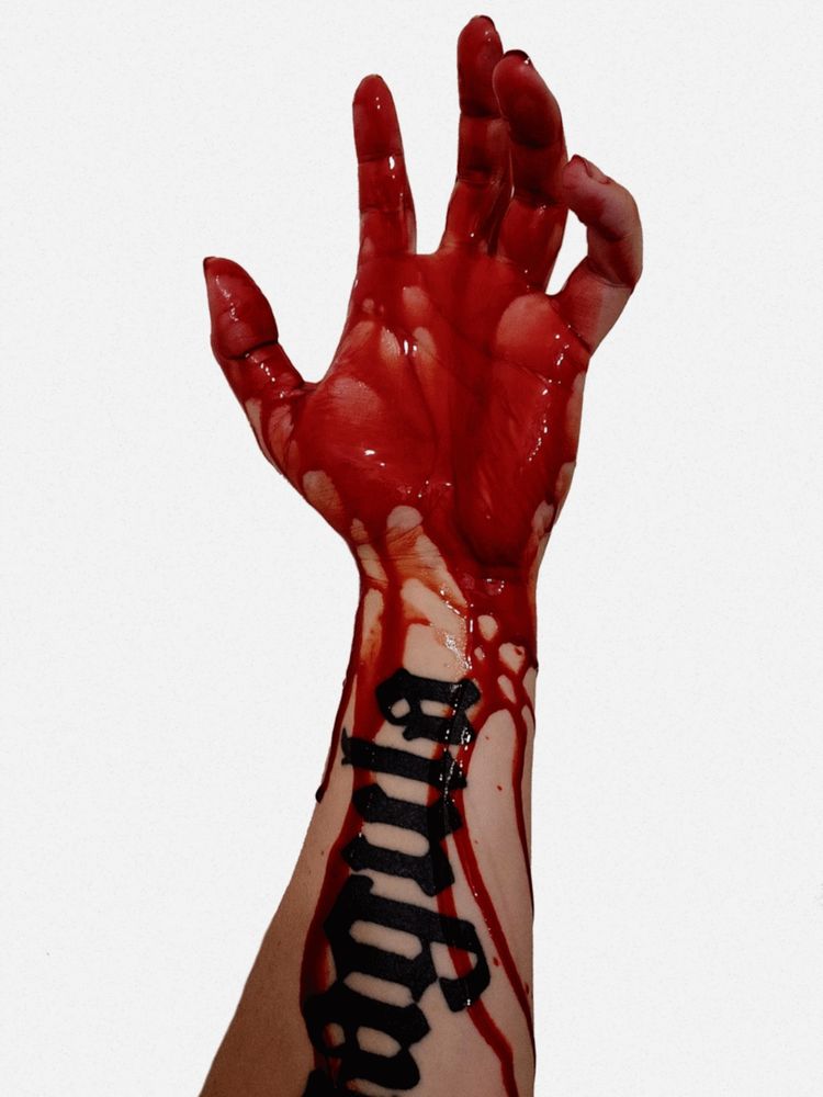 A photograph of Asheroth's hand coated in blood. She has a visible forearm tattoo that says "coagula".