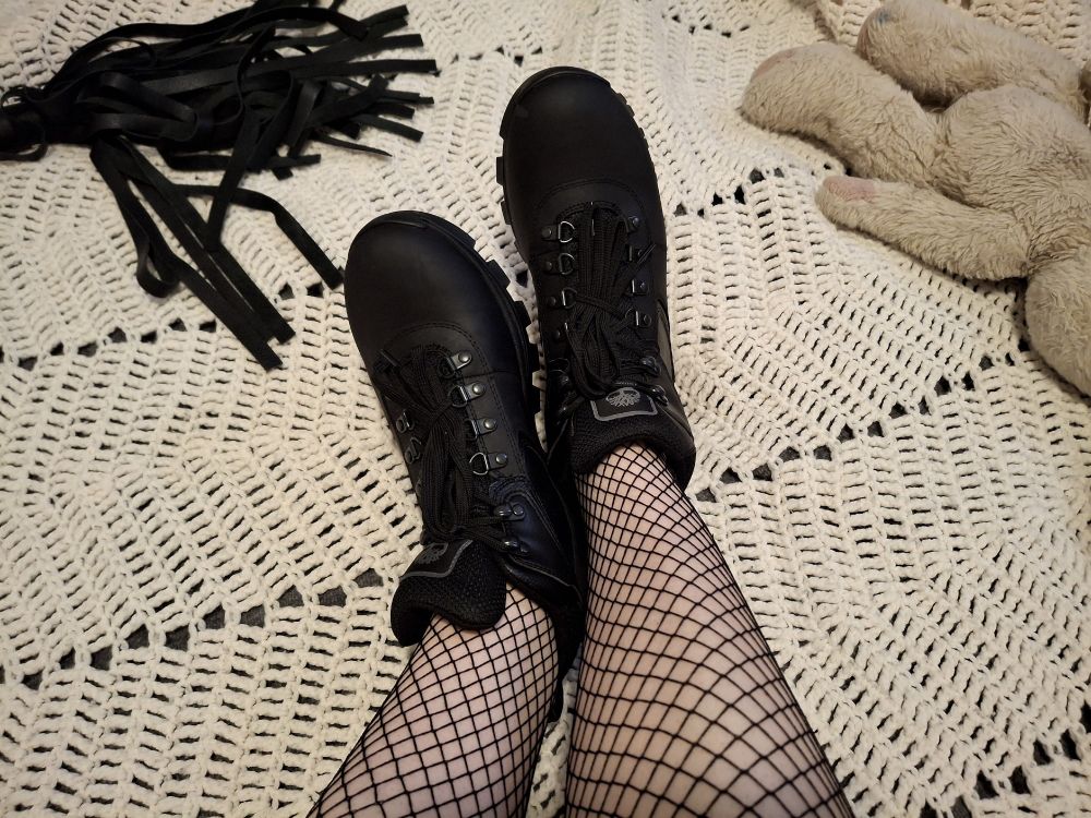 Ash laying on her bed, wearing fishnets and a new pair of all-black Timbs.