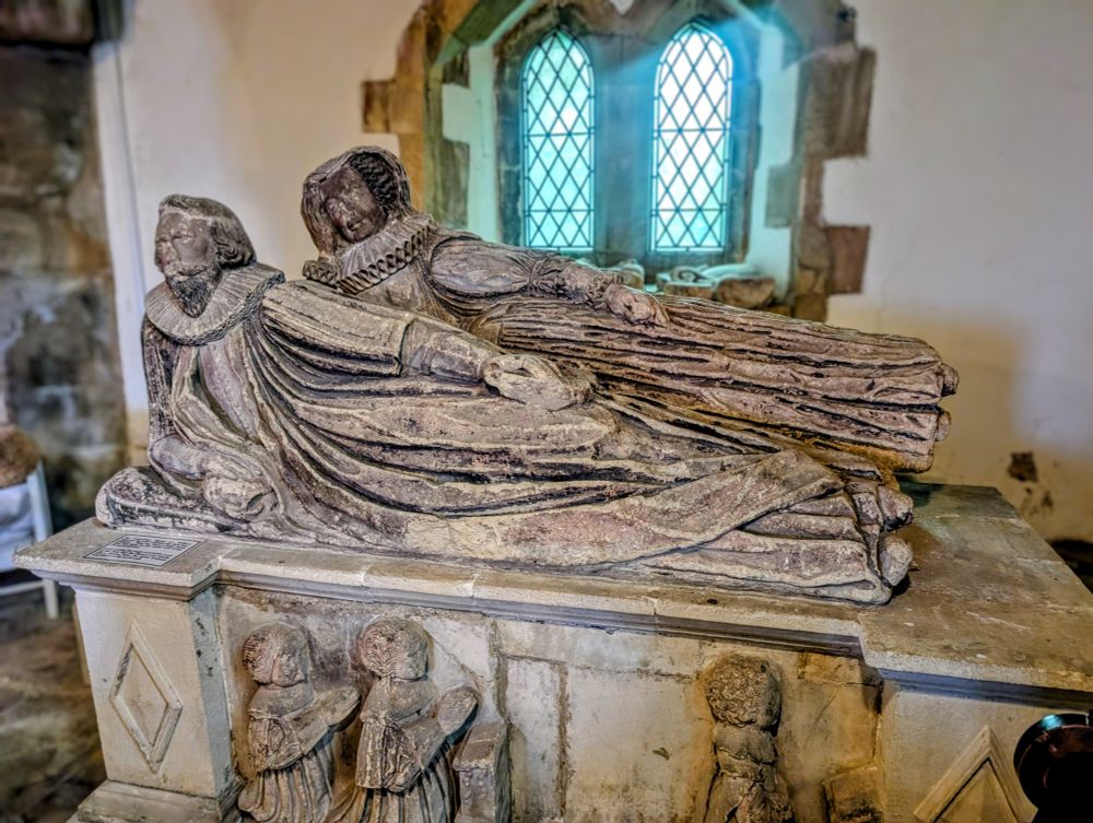Zwei liegende Steinskulpturen, eine Frau und ein Mann, auf einer Grabplatte in der Kirche von St Briavels.