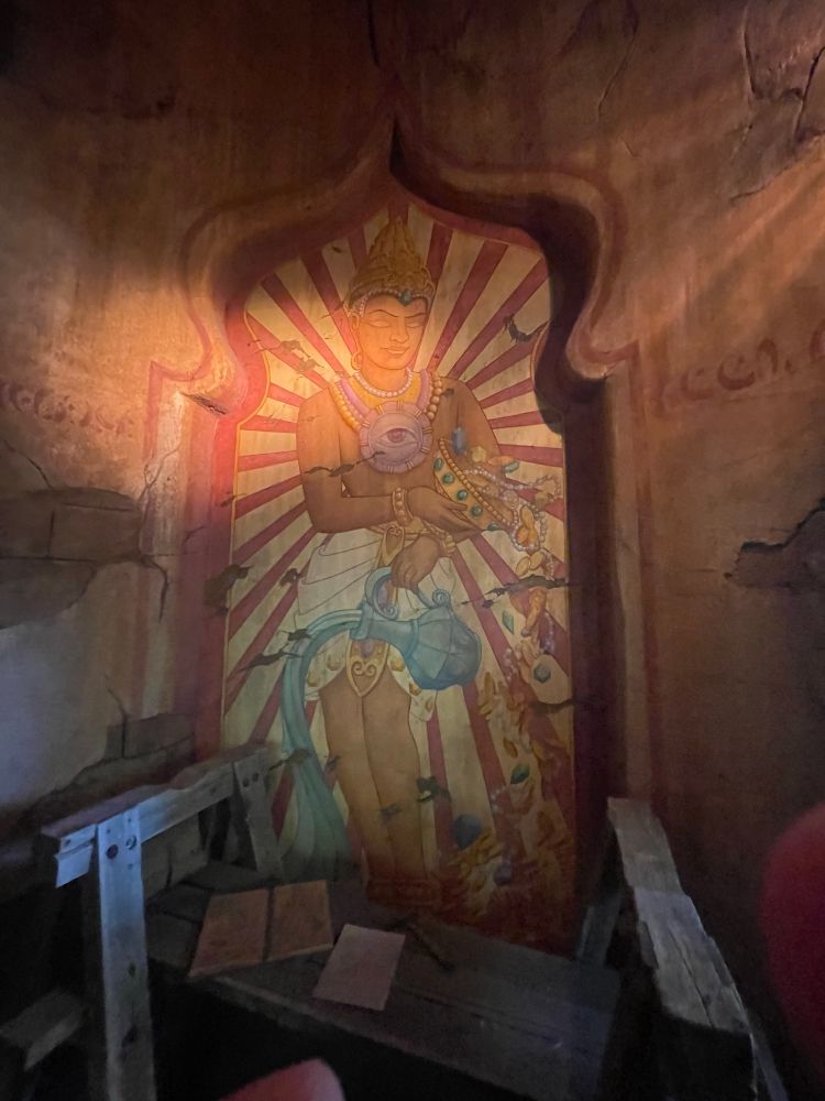 Painting of Mara in the queue of Indiana Jones, with a ruined desk in the foreground. 