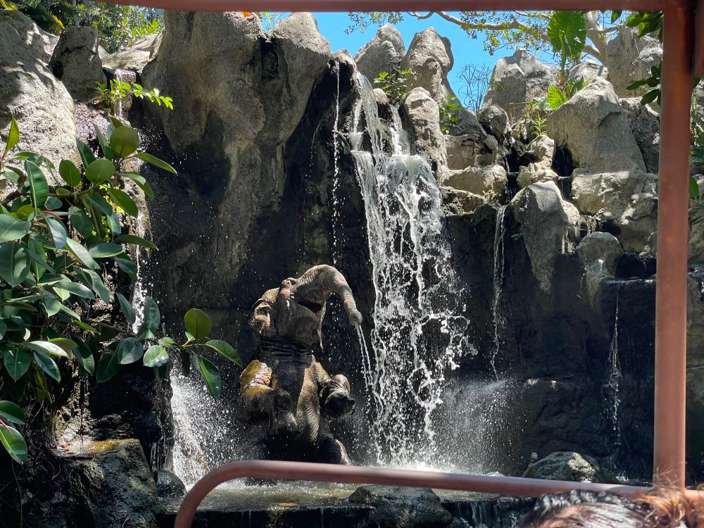 Elephant bathing under a waterfall.  
