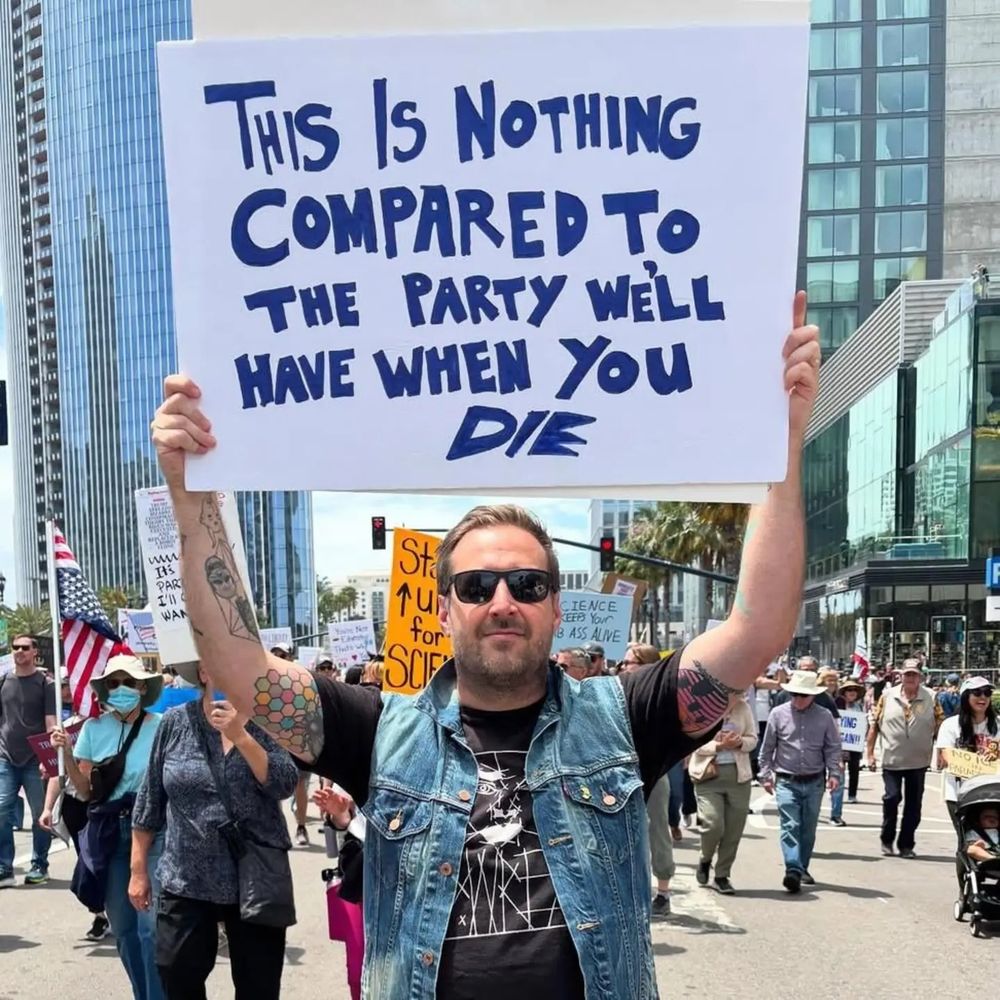 A person at this past weekend's No Kings protests, holding up a sign that says "This is nothong compared to the party we'll have when you die"