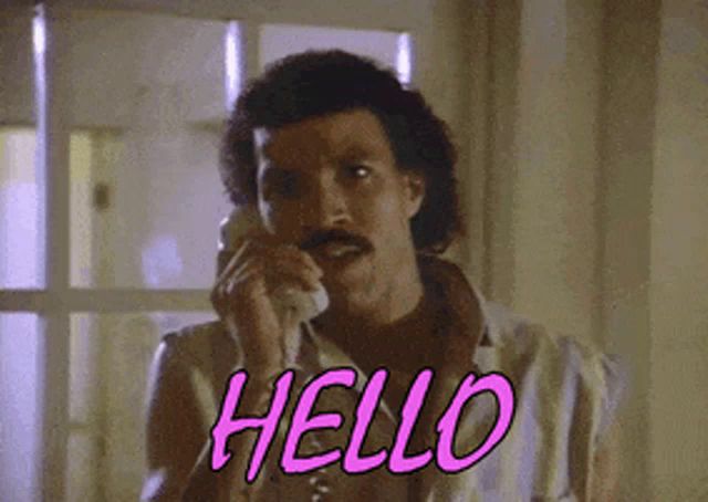 a man with a mustache is talking on a phone and saying hello