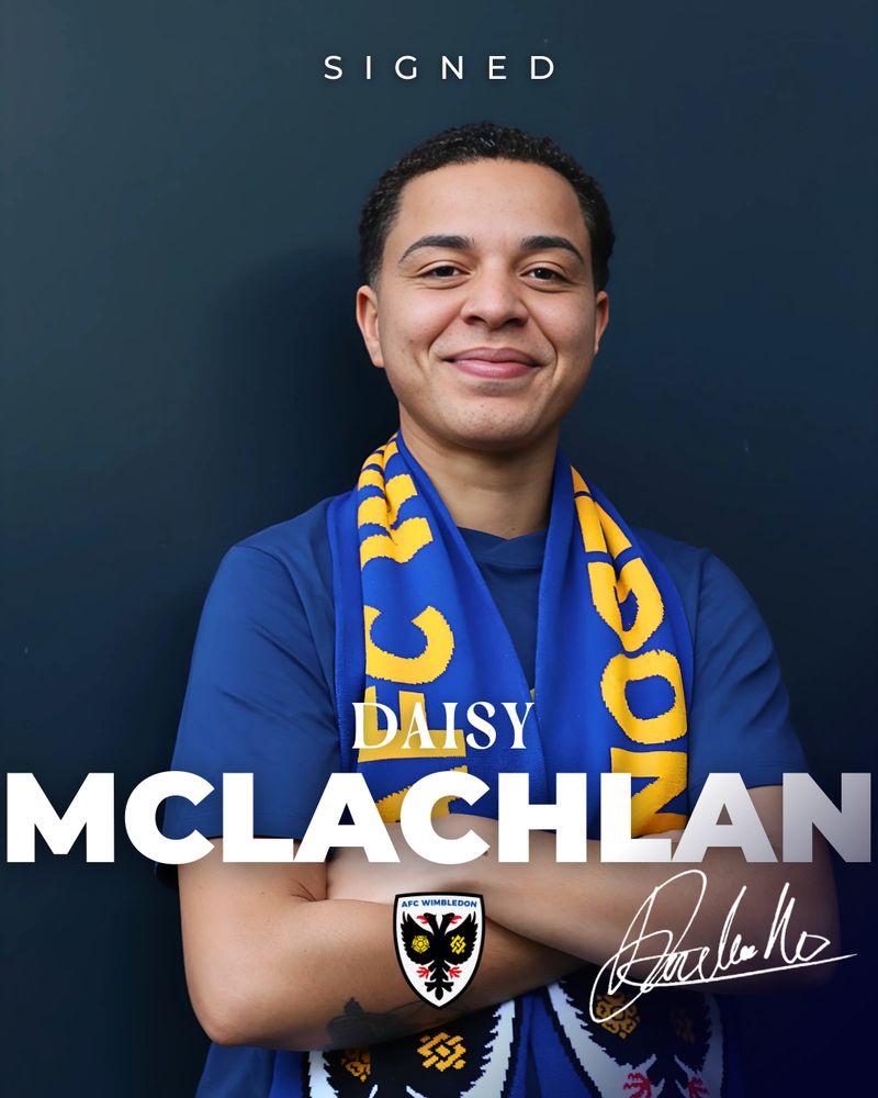 Daisy McLachlan standing in front of a wall, wearing an AFC Wimbledon scarf, with her arms crossed over her chest. 
The text at the top reads "signed", the text at the bottom reads "Daisy McLachlan". 
The AFC Wimbledon crest is at the bottom down the middle, and Daisy's autograph is in the right bottom corner. 