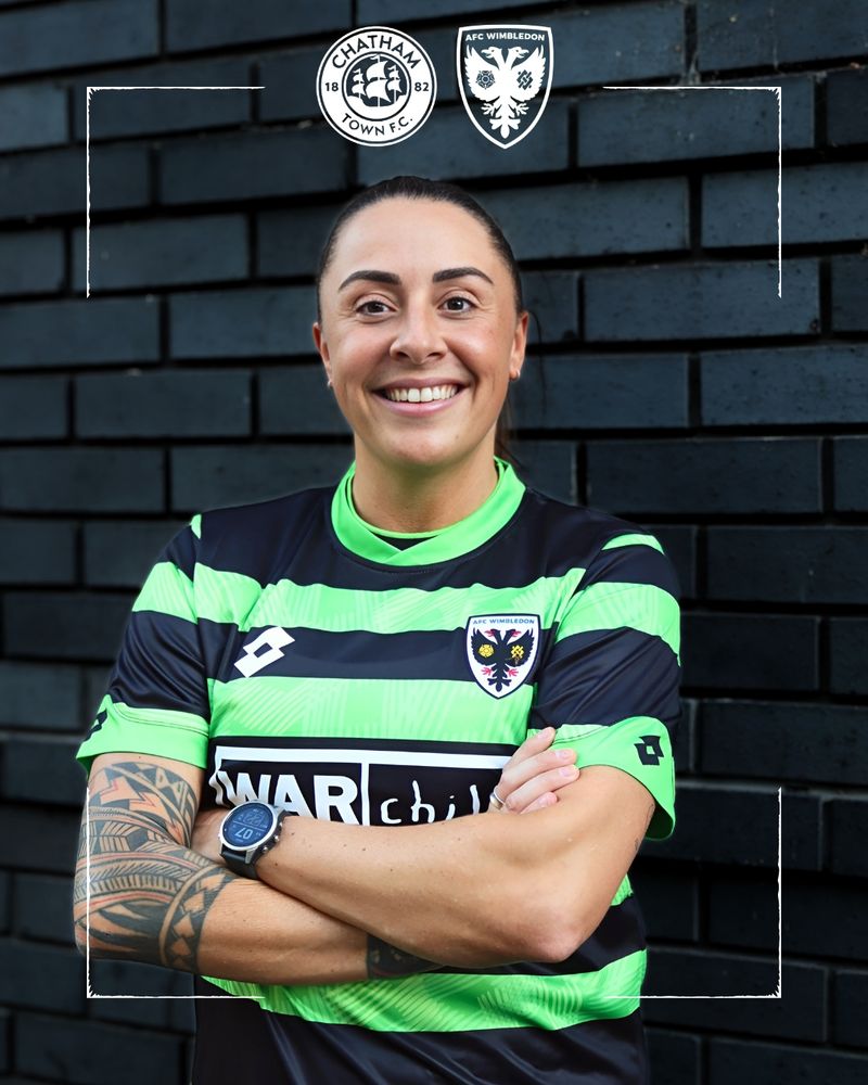Footballer Ashlee Hincks, standing in front of a black brick wall. She has her arms crossed, and she is wearing a black and green horizontally striped top. The crests of Chatham Town and AFC Wimbledon are at the top. 