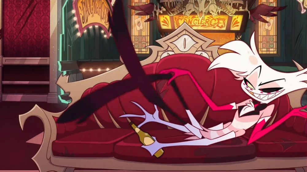 Angel dust from Hazbin Hotel season 1. The spider sinner is lounging on a red couch, bottle of alcohol in hand.